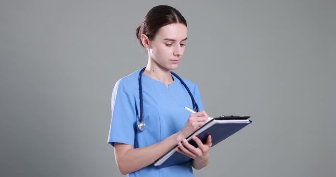 Medical assistant with clipboard and folder on light grey background