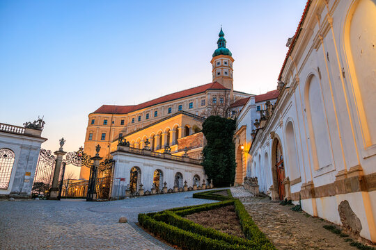 Historic castle architecture at sunset with cobblestone path and ornate gate. March 19, 2026, Mikulov, Czech Republic