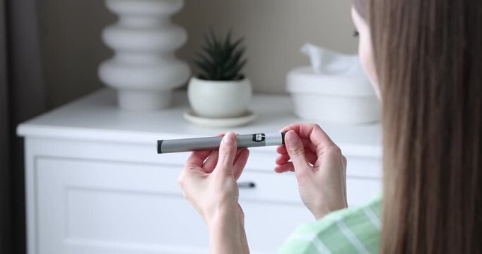 Diabetes. Woman with autoinjector at home, closeup