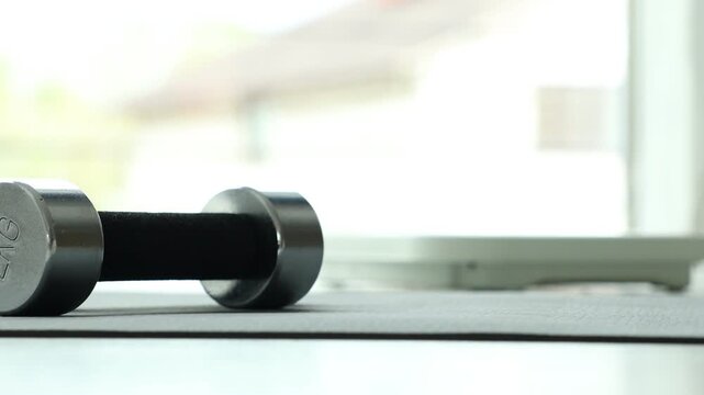Woman taking measuring tape and standing on scales indoors, selective focus
