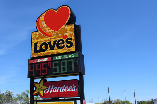 Love's travel stop sign with fuel prices for diesel and gasoline. Hardee's restaurant sign below (Wisconsin, USA - May, 14, 2026). Editorial Use Only.
