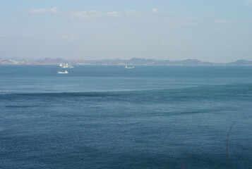 Fototapeta premium Deep big blue sea landscape with a dramatic tidal current line and cargo ships