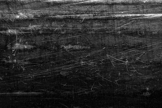 Black scratched grunge texture background, distressed paper surface with white dust and grain