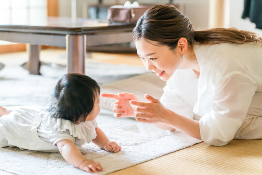 A crawling baby and a smiling mother, a mother playing with her child