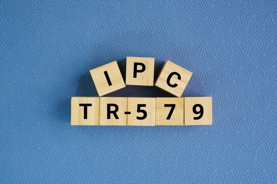 Wooden cube with the word IPC-TR-579. Round Robin Reliability Evaluation of Small Diameter Plated Through Holes in Printed Wiring Boards. foundational technical report and fatigue life prediction 