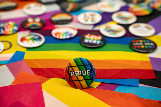 Pride badge on LGBTQ rainbow flags background.