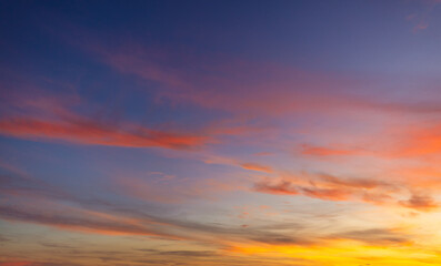 Fototapeta premium Vibrant Colorful Sunset Sky with Dramatic Clouds,A breathtaking view of a vibrant sunset sky filled with dramatic streaks of orange, pink, and purple clouds, creating a peaceful and inspiring.