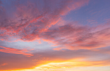 Fototapeta premium Vibrant Colorful Sunset Sky with Dramatic Clouds,A breathtaking view of a vibrant sunset sky filled with dramatic streaks of orange, pink, and purple clouds, creating a peaceful and inspiring.