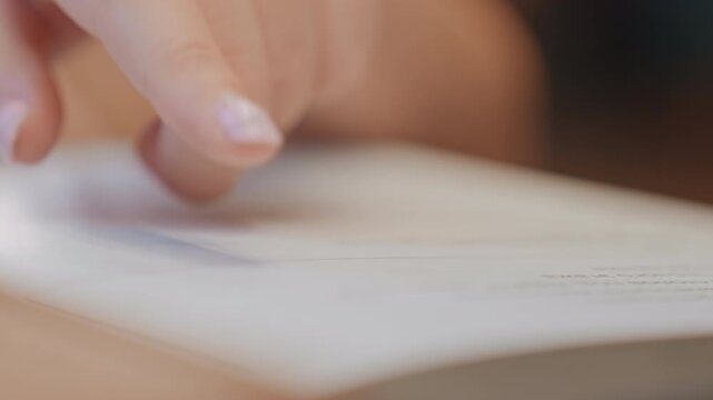Closeup hand tracing text on paper, student finger follows printed line, soft warm lighting, shallow depth of field, subtle manicure, focused study atmosphere, quiet classroom background