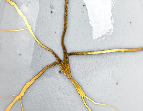 Hammered silver and gold Japanese kintsugi ceramic texture with crack repair lines