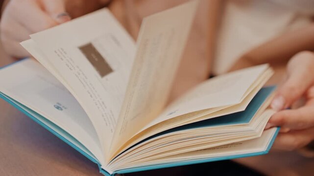 Fast hands flipping textbook pages, focused study session, notes visible, quick review for exam, student or researcher analyzing citations, blue hardcover, binding details, disciplined study routine,