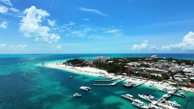 Wide aerial view flying forward toward Playa Norte in Isla Mujeres, Mexico. Smooth 4K 60fps drone shot showcasing a vibrant white sand beach, luxury yachts, and turquoise sea.