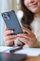 Vertical closeup image of a woman using smart phone at home