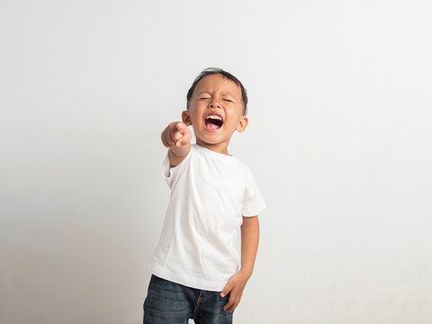 Small asian boy points his finger upward while shouting loudly with a wide open mouth and expressive face in this clear studio photo focusing on childhood emotion and energetic gestures.