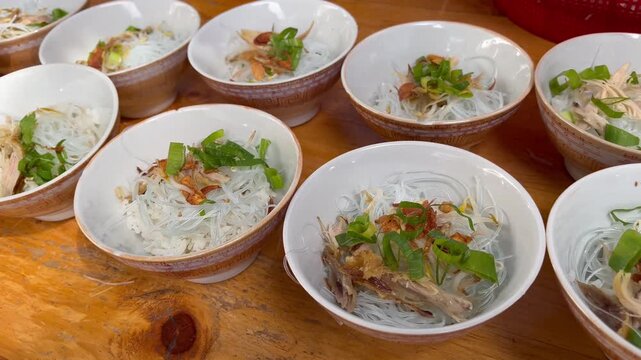 Traditional Indonesian soto soup served in bowls on wooden table