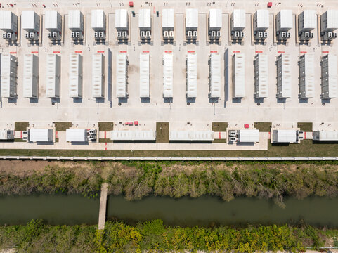 Aerial view of white semi trucks parked in neat rows at a logistics center