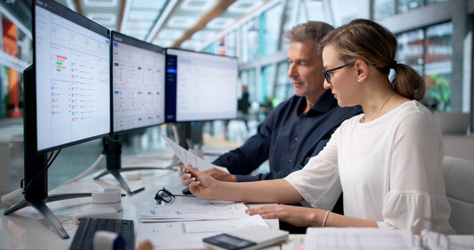 Two Accountants Review Receipts And Spreadsheets Together