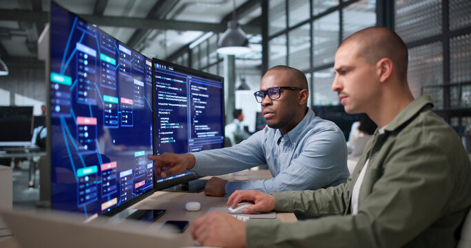 Two Young Black Men Collaborate On Visual Workflow Editor