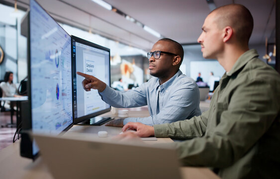 Two Men Analyze Compliance Data Together