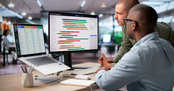 Project Manager And Team Review Digital Gantt Chart Tracking Project