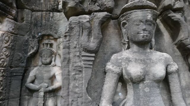 Ancient stone carving of a female deity at Angkor Wat, Cambodia. The intricate bas-relief depicts a celestial dancer, a common motif in Khmer art.