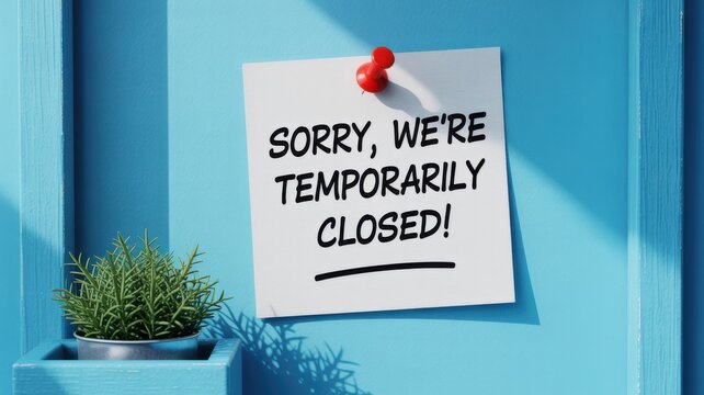 Sorry we are temporarily closed sign pinned to blue wooden background