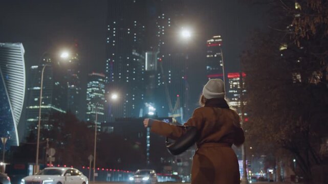 City night skyline white woman dancing with arms out, coat and bag in hand, skyscraper lights and busy traffic, reflective pavement and motion blur, spontaneous joyful stride across boulevard, urban