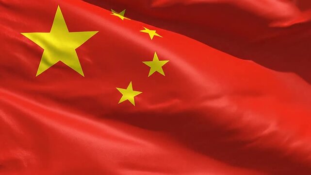 A bright red fabric flag featuring five yellow stars waving in the wind