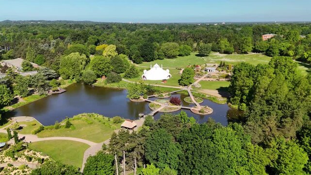 Hamburg, Germany - 27 May 2026: Aerial view of Loki Schmidt Garden Botanical of University Hamburg with its iconic white dome, serene pond, and lush green trees under a clear sky.