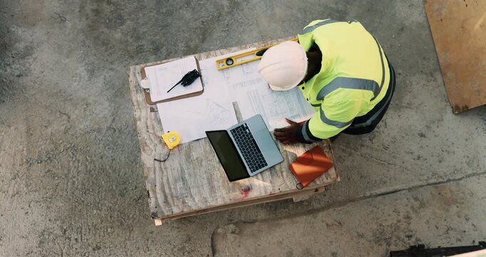 Construction site, laptop and above of man for planning, building design and inspection. Civil engineering, supervisor and person with documents and tech for floorplan, blueprint and infrastructure