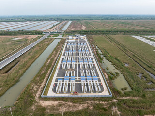 Aerial view of rural water treatment facility surrounded by green farmland and irrigation canals