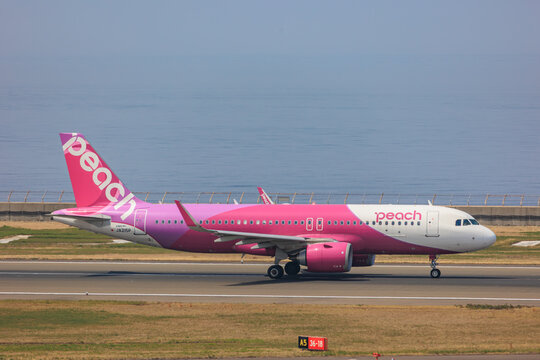 Tokoname, Aichi, Japan - April 19, 2025: A Peach Aviation Airbus A320neo (Registration JA215P) taxiing on the runway with the Ise Bay ocean in the background at Chubu Centrair International Airport.