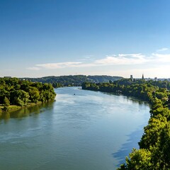 Obraz premium River meanders through lush green landscape under a vibrant blue sky