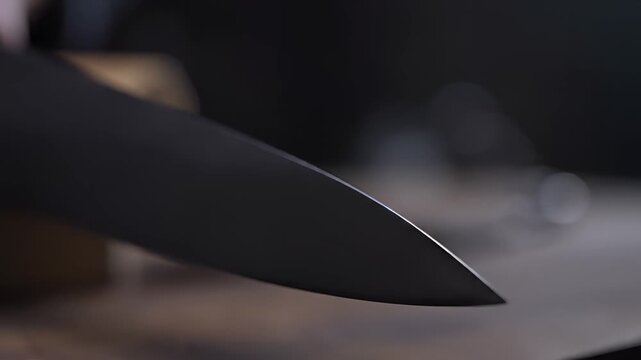 Closeup of a sharp knife blade glistening under soft light.