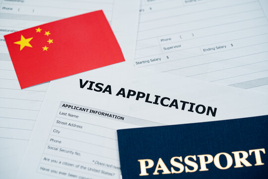 View of China visa application form with passport and national flag.