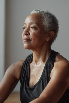 Elderly Black woman practicing seated Pilates breathing exercise. Calm, mindful movement for healthy aging. Afro american senior woman breathing exercises, healthy aging theme. Diversity.
