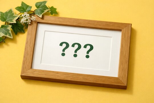 Three green question marks in a wooden frame with ivy