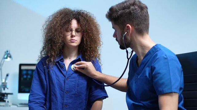 Medical concept.doctor listens to patient's heartbeat using a stethoscope during a health check.