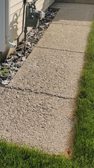 Obraz premium Exposed Aggregate Sidewalk Along Residential Home