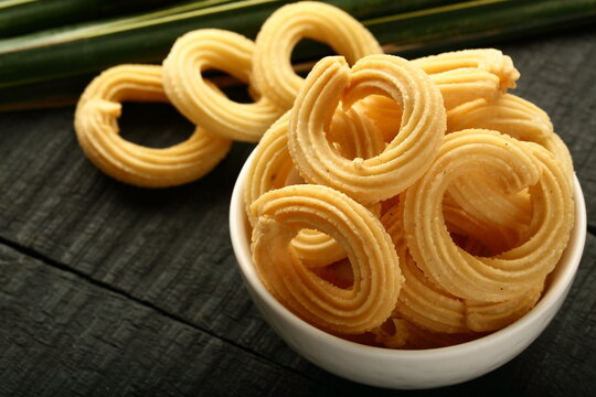Crispy and crunchy festive murukku chakli snack served in a white ceramic bowl on a wooden background.