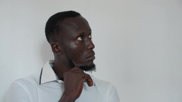 Professional man considering future actions carefully. Thoughtful male professional reflecting on upcoming strategic decisions. Serious looking man in white shirt deep in planning and analysis