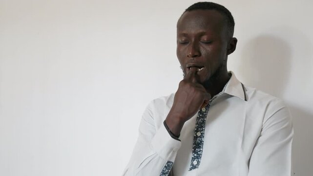 Black man straightening tie before date, white shirt, adjusting collar, pensive expression, soft studio light, office worker preparing for romantic evening, gentle pause, hopeful anticipation