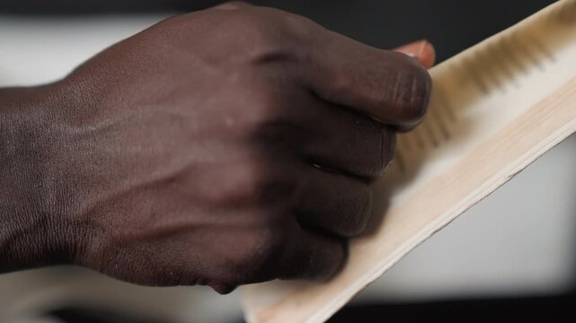 Black man hands flipping poetry pages, closeup, gentle turning, preparing romantic reading for date night, soft studio light, textured paper, focused fingers tracing lines, intimate rehearsal mood