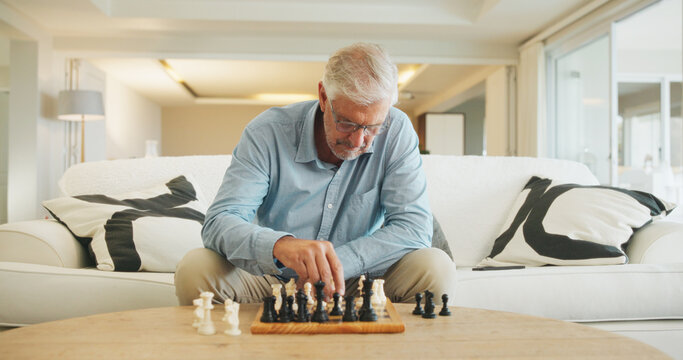 Old man, chess and game on couch with strategy, solution or problem solving in contest in living room. Senior person, boardgame and idea with competition for thinking, knowledge or challenge in home
