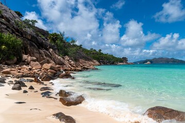Obraz premium Rocky tropical beach with turquoise water and dramatic clouds - Seychelles