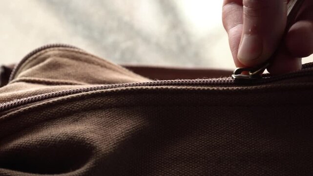 Close-up of a brown bag opening with a zipper, retro style