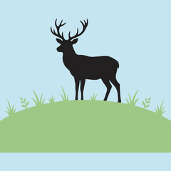 A black silhouette of a deer stands on a green grassy hill © Irfan