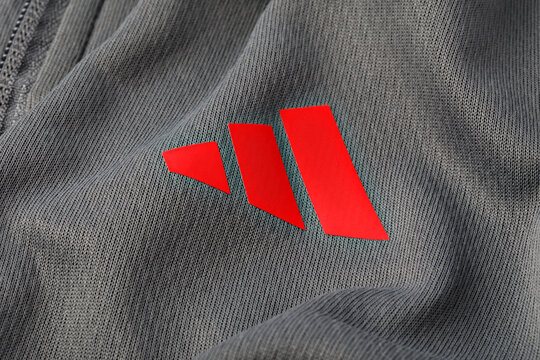 Adidas logo red three stripes on grey fabric