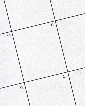 Close-up of a blank calendar page grid with dates 14, 15, 21, and 22 visible on textured white paper.