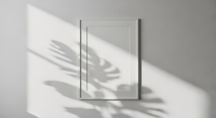Naklejka premium Blank white poster frame mockup on wall with leaf shadows